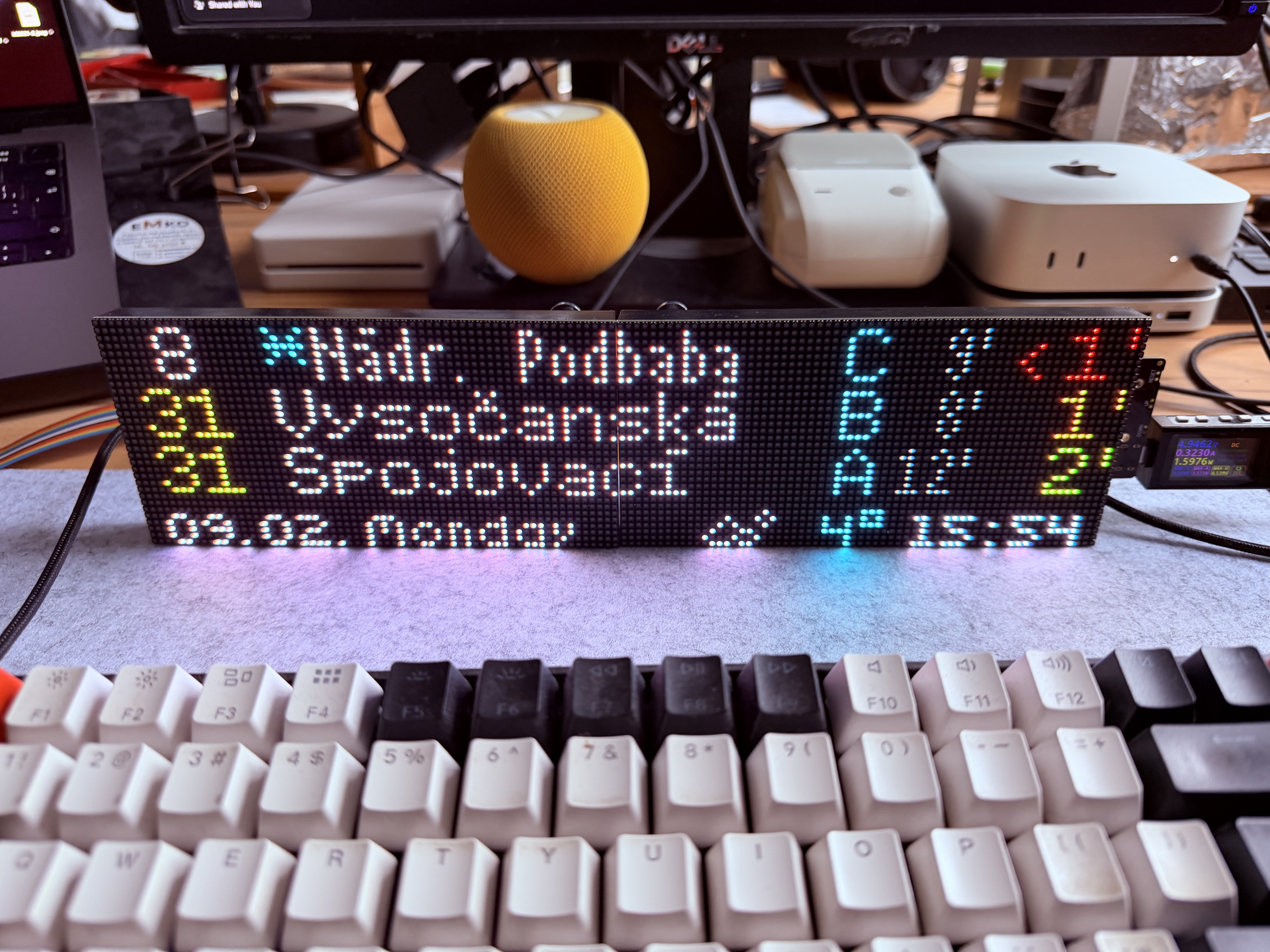 SpojBoard on desk showing Prague trams with dual ETA and weather